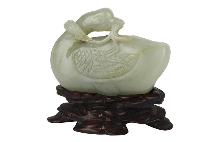 A PALE GREEN JADE CARVING OF A ... 