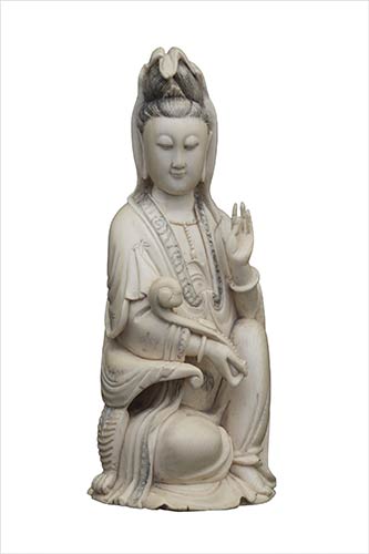 AN IVORY CARVING OF A SEATED ... 