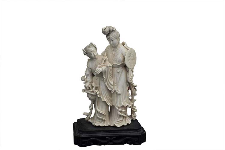 AN IVORY CARVING OF TWO STANDING ... 