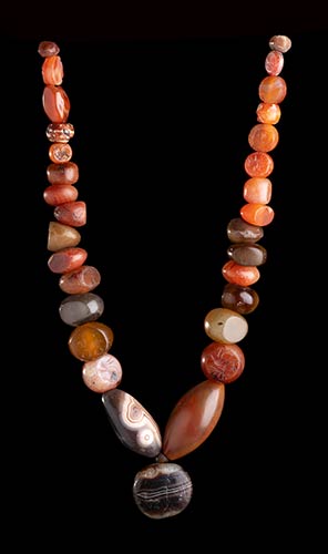 A CARNELIAN AND AGATE BEADS, SOME ... 