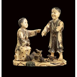 AN IVORY CARVING OF TWO FIGURES AND ... 