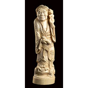 AN IVORY CARVING OF A STANDING GAMA ... 