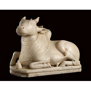 A WHITE MARBLE SCULPTURE OF A  RESTING NANDI ... 