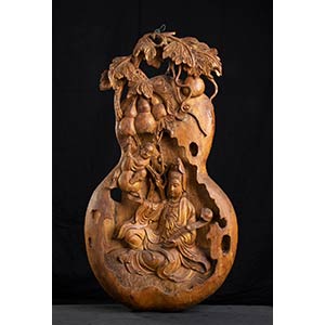 A WOOD GOURD-SHAPED PANEL WITH GUANYIN AND A ... 