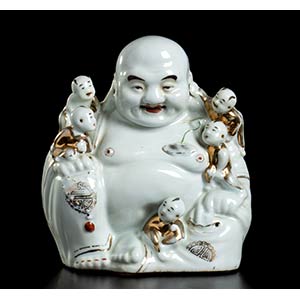 A PARTIALLY GILT PORCELAIN SEATED BUDAI WITH ... 