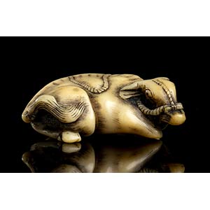 A HORN NETSUKE WITH A RECUMBENT ... 