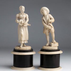 A pair of carved ivory figures of street ... 