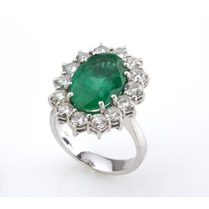 EMERALD AND DIAMOND RING; set with an oval ... 