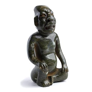 AN GREEN STONE CARVING OF A KNEELING MALE ... 