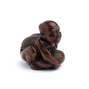 A WOOD NETSUKE OF A MAN WITH DEFORMED ... 