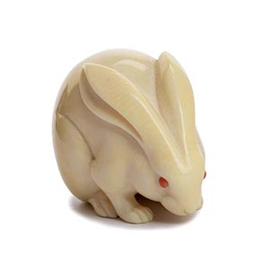 A CORAL INLAID IVORY NETSUKE OF A RABBIT20th ... 