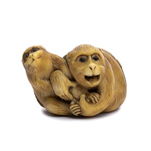 A HORN INLAID IVORY NETSUKE OF A MONKEY AND ... 