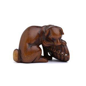 A HORN INLAID WOOD NETSUKE OF A DOG AND ... 