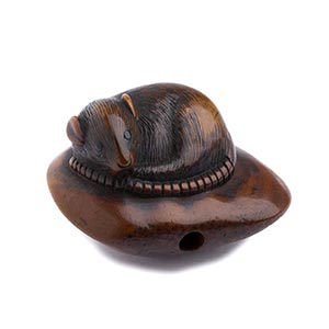 A HORN INLAID WOOD NETSUKE OF A MOUSE ON A ... 